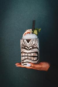 a hand holding a drink with at Aloft London Excel in London