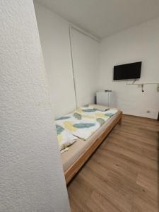 a bedroom with a bed and a flat screen tv at Pension Hirsch in Berg