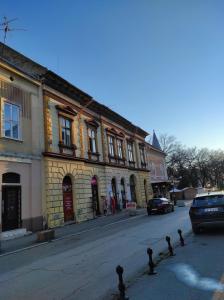 a building on a street with cars parked in front of it at Apartman DRAGIN SAN in Subotica