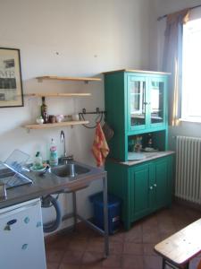 a kitchen with green cabinets and a sink at Olivella Suite Ecological House in Palermo