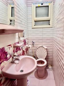 a pink bathroom with a sink and a toilet at ALEX HOMES - Stanley Cozy Apartments with Direct Sea View in Alexandria