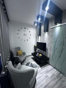 a living room with a couch and a clock on the wall at Apartment SaGo in Clausthal-Zellerfeld