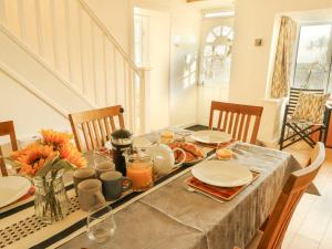 a dining room table with food and flowers on it at Bryn Teg Cottage in Moelfre