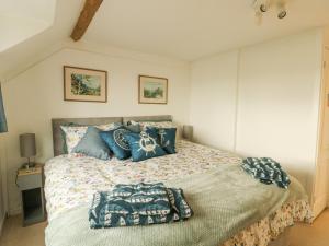 a bedroom with a large bed with blue pillows at Bryn Teg Cottage in Moelfre