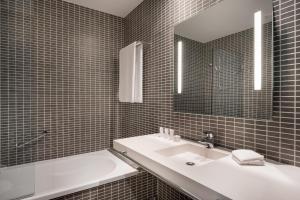 ein Badezimmer mit Waschbecken und Spiegel in der Unterkunft AC Hotel by Marriott Alicante in Alicante