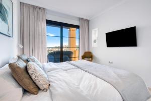 een slaapkamer met een groot wit bed en een groot raam bij Gadea 11-2 in Altea