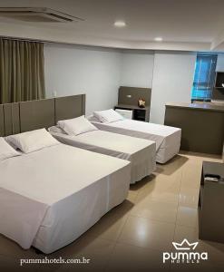 a hotel room with three beds and a kitchen at Pumma Business Hotel in Canaã dos Carajás