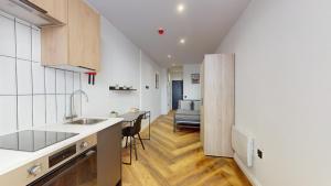a kitchen with a sink and a dining room at The Thurloe Studios in Manchester