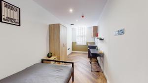 a bedroom with a bed and a desk in it at The Thurloe Studios in Manchester