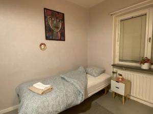 a small bedroom with a bed and a window at 6 rum lägenhet 90kvm parkettgolv balkong öppen spis hög takhöjd in Ljungaverk