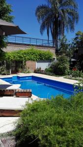 a swimming pool with a bench next to a building at Posada Villa club, Apart 3 cerca del aeropuerto el Palomar in Hurlingham