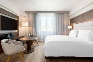 a hotel room with a bed and a desk and a tv at AC Hotel by Marriott Wroclaw in Wrocław +37 photos
