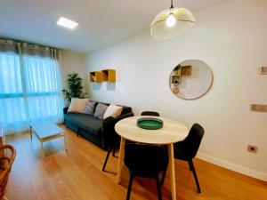 ein Wohnzimmer mit Tisch und Couch in der Unterkunft Las Canteras Deluxe in Las Palmas de Gran Canaria