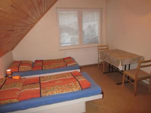 een kamer met drie bedden en een tafel en een stoel bij Apartments Centrum in Liptovský Mikuláš