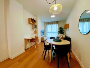 ein Wohnzimmer mit Tisch und Couch in der Unterkunft Las Canteras Deluxe in Las Palmas de Gran Canaria + 26 Fotos