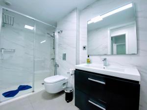 ein Badezimmer mit Toilette, Waschbecken und Dusche in der Unterkunft Las Canteras Deluxe in Las Palmas de Gran Canaria