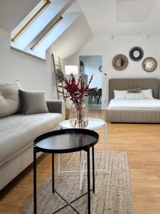 a living room with a couch and a table with a vase at PARKOVA APARTAMENTY - termy, centrum, park in Jelenia Góra