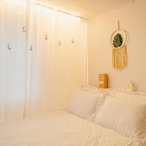 a bedroom with a white bed with a mirror on the wall at Noddle Sun Stay in Seoul