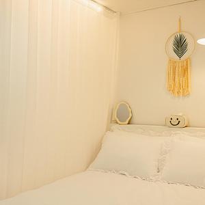 a white bedroom with a bed and a clock on the wall at Noddle Sun Stay in Seoul