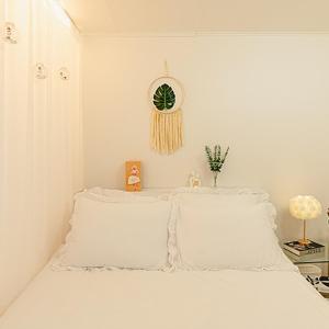 a bedroom with two white beds and a clock on the wall at Noddle Sun Stay in Seoul