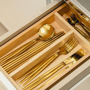 a wooden drawer with gold utensils in it at Noddle Sun Stay in Seoul