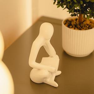 a white figurine sitting on a table next to a vase at Noddle Sun Stay in Seoul