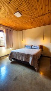 a bedroom with a large bed with a wooden ceiling at Vista Verde Tiradentes in Tiradentes