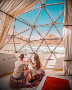 a man and a woman sitting in front of a window at Wadi Rum Relaxation Camp in Wadi Rum +131 photos