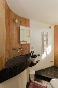 ein Badezimmer mit einem schwarzen Waschbecken und einem Spiegel in der Unterkunft Casa Bianca nello Junno in Mattinata