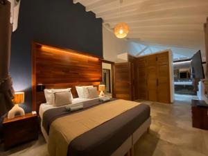 a bedroom with a large bed with a wooden headboard at Villa passion vanille in Les Trois-Îlets +63 photos