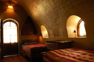 a bedroom with two beds and two windows at ALLKAMARI Eco-Resort&Spa in Uni