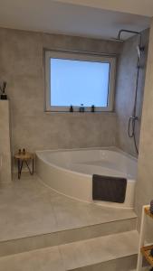 a white bath tub in a bathroom with a window at Appartement Apelern (A2) - 2 Zimmer, Badewanne, Terrasse, Netflix in Apelern
