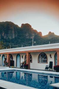 a house with a swimming pool next to a mountain at Casa Arcos Tepoztlán in Tepoztlán
