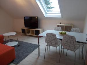a living room with a table and chairs and a tv at Apartment Seven Ducks in Aalen