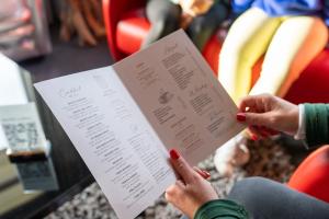 a woman holding a piece of paper with her hands at Hôtel La Réserve in Gérardmer