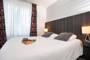 a bedroom with a large white bed and a window at Hôtel La Réserve in Gérardmer