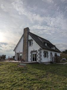 a white house with a chimney on top of a field at Maison familiale 6 chambres, vue imprenable in Pléboulle