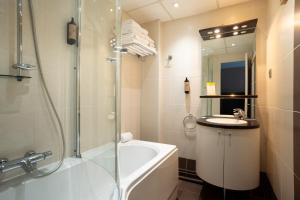 Un baño con ducha, bañera y lavabo. en Hôtel La Réserve, en Gérardmer