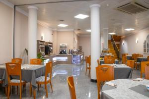 a restaurant with tables and chairs and a kitchen at Hotel Las Moradas in Ávila