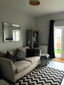 a living room with a couch and a mirror at Nidd House Apartment in Harrogate