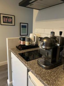 a kitchen counter with a coffee maker on a stove at Nidd House Apartment in Harrogate