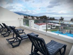 a group of chairs on a balcony with a view at Sunrise House 26 in Ponta Delgada