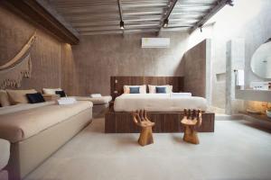 a bedroom with a bed and a couch with two wooden hands at Luxury 2BR House with Ocean View in Castillogrande in Cartagena de Indias