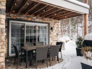 a patio with a table and chairs in the snow at Ski in out at La Halte Mont-Blanc 2 in Mont-Blanc