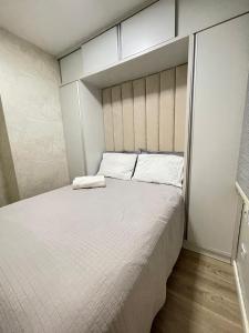 a bedroom with a large bed with white sheets at Hian's Place 01 in Foz do Iguaçu