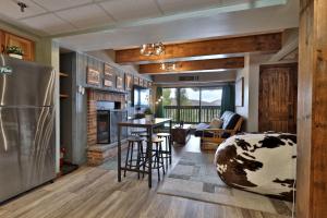 a kitchen and living room with a refrigerator and a table at The Mountain Green Nook with Views, Shuttle Bus, Pools, Hot Tub, Gym, Ski Shop, Restaurant in Killington