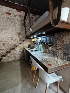 eine Küche mit einer Theke und einer Steinmauer in der Unterkunft Duplex en Getsemani TWON in Cartagena de Indias