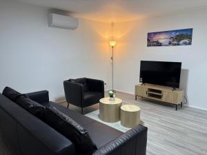 a living room with a couch and a flat screen tv at An enchating and enriching home in Fairfield