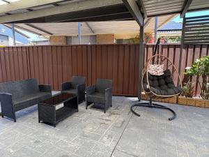 a patio with chairs and a bench and a swing at An enchating and enriching home in Fairfield