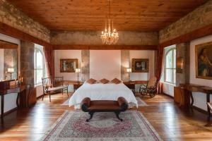 a bedroom with a bed and a chandelier at Hacienda La Cienega in Latacunga